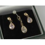 A suite of jewellery comprising earrings and pendant, white teardrop shaped stones,