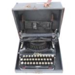 A vintage c1920-40s Erika folding typewriter having keys, ribbon and original box.