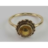A 9ct gold and citrine ring, central round cut stone in rope twist pattern setting, hallmarked 375,