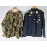 A quantity of assorted repro WWII German tunics, trousers and caps.