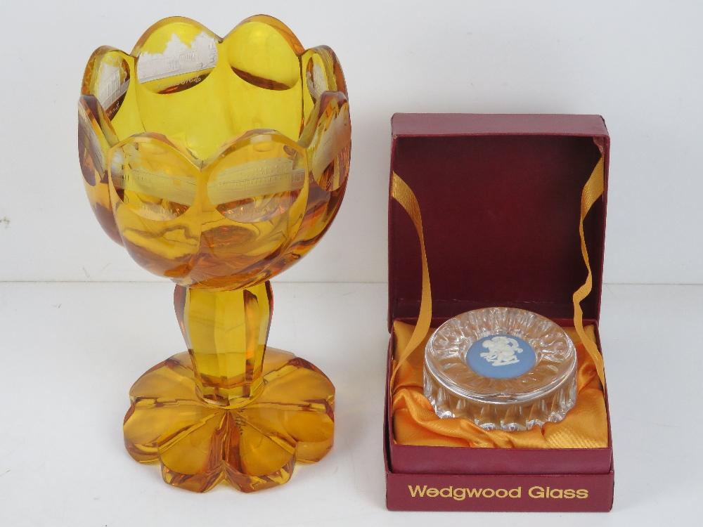 An amber glass goblet having etched German town upon,