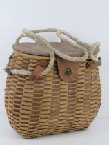 A woven and leather fishing catch basket approx 30cm wide.