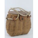 A woven and leather fishing catch basket approx 30cm wide.