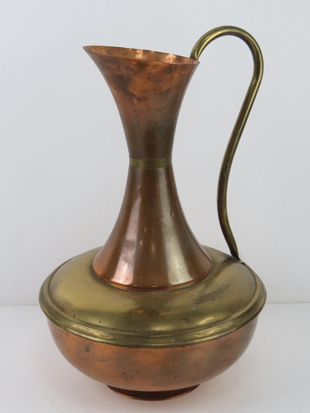 A large copper and brass jug standing 45cm high.
