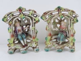 A pair of lattice ware ceramic figural garden floral encrusted seats with boy and girl upon,