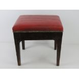 A footstool upholstered in red leather 37 x 32 x 34cm.