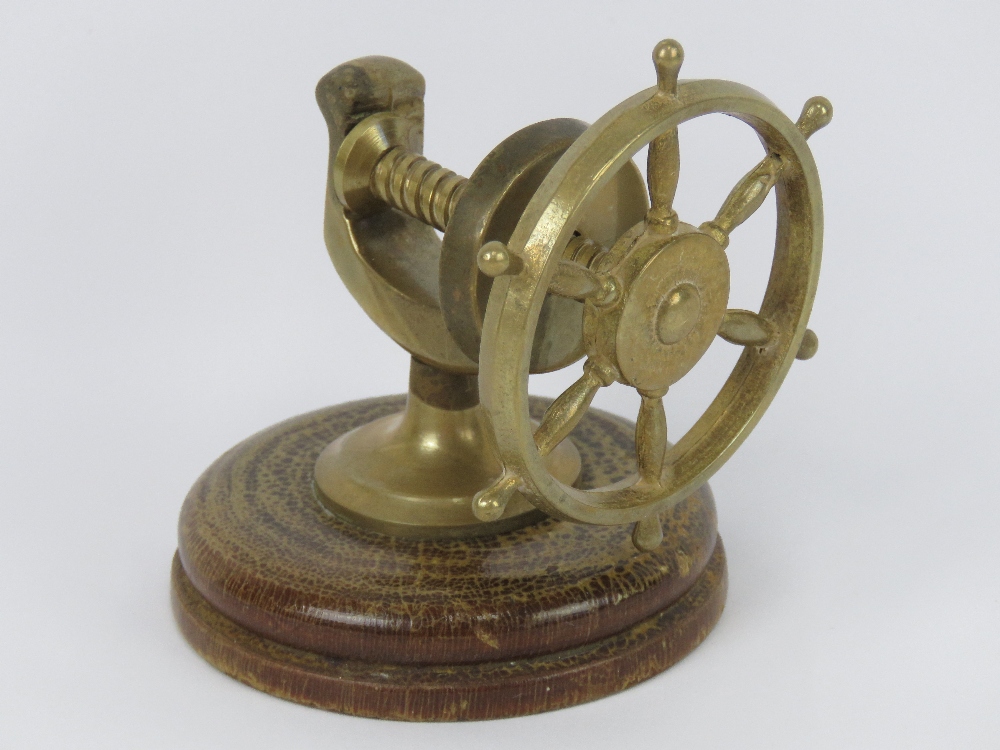 A brass nut cracker in the form of a ship's wheel.