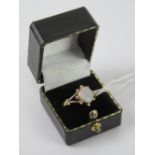 A contemporary 9ct gold and opal ring, the central oval cabachon having good multi colour fire,