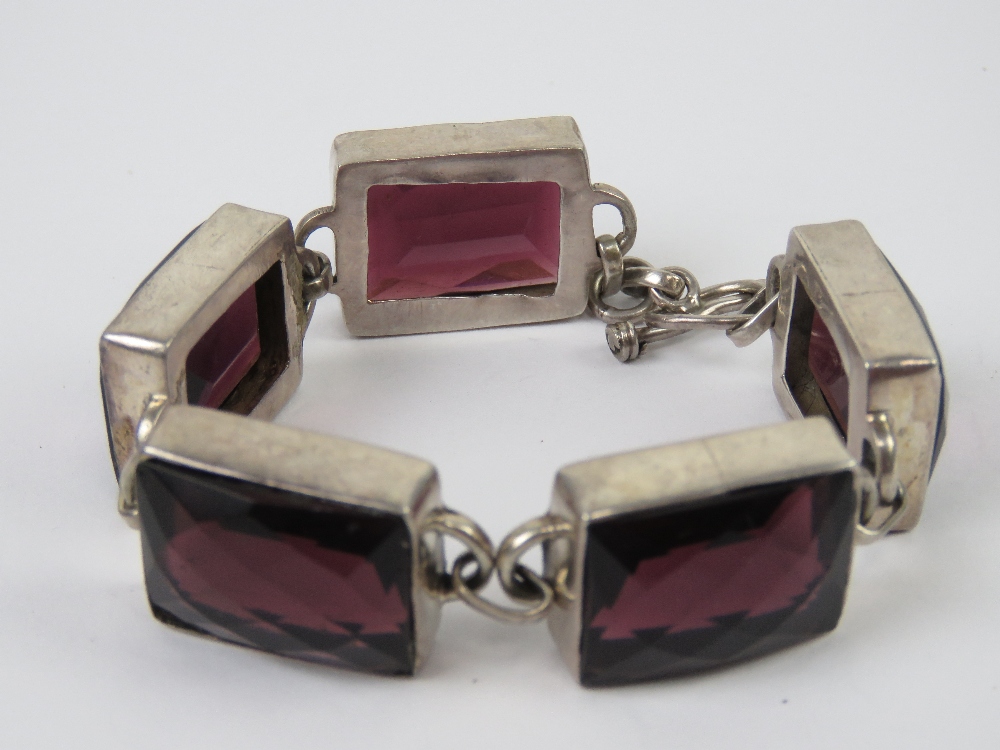 A five panel bracelet each set with faceted garnet coloured paste, no apparent hallmarks, - Image 2 of 3