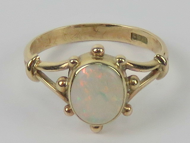 A contemporary 9ct gold and opal ring, the central oval cabachon having good multi colour fire, - Image 3 of 4