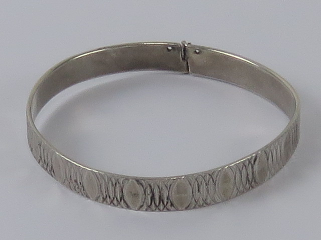 A HM silver bangle having overlapping oval pattern upon, London Jubilee hallmark upon, 5.2cm dia.