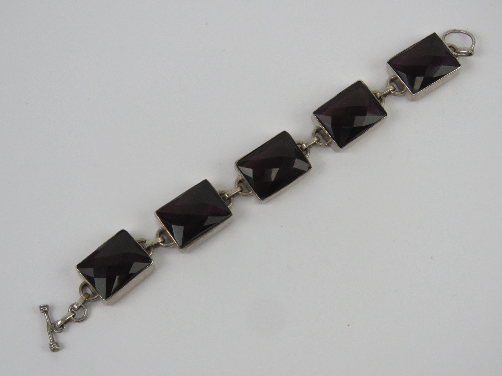 A five panel bracelet each set with faceted garnet coloured paste, no apparent hallmarks,