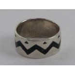 A Native American Navajo style ring with inset zigzag pattern crushed turquoise, stamped 925,