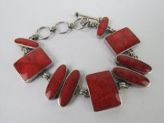 A silver and faux coral bracelet, oval and rectangular panels, stamped 925,