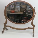 An Edwardian oval mahogany toilet mirror.