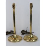 A pair of brass table lamps of column form.