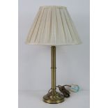 A single brass table lamp of column form, with shade.