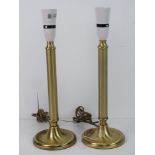 A pair of brass table lamps of column form.