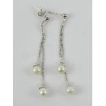 A pair of 18ct white gold and pearl earrings, stamped 750, 6cm drop, one buterfly back, 4.12g.