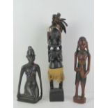 Three carved and decorated fertility statues, shortest 26cm high.