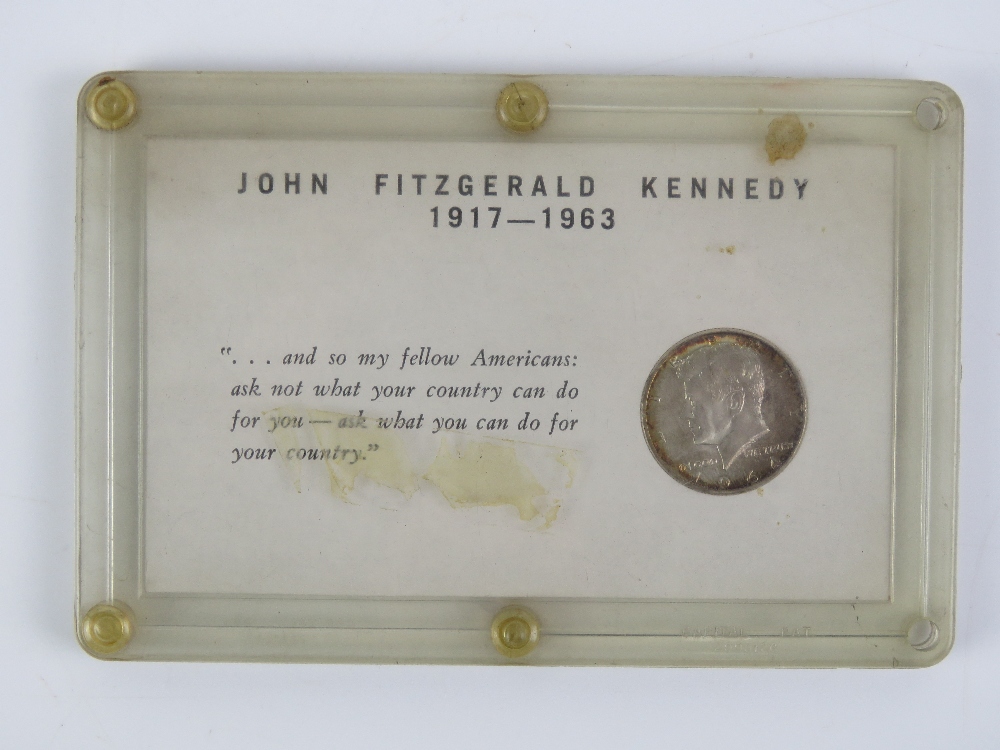 A John Fitzgerald Kennedy (JFK) 1917-1963 commemorative 1964 half dollar coin in plastic pod.