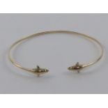 A 14ct gold bangle having dolphin terminals, stamped 585, 2.96g.