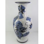A large floor standing white ground vase having blue Chinese dragon design, 65cm high.