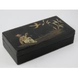 A Chine black lacquered pen box having gilt design with figure and bird upon, 15.5cm wide.