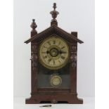 A vintage mantle clock having wooden case with glazed door, brass and paper dial.