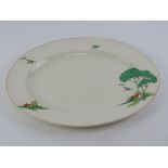 An Art Deco meat plate having Clarice Cliff Bizarre style pattern featuring trees houses and