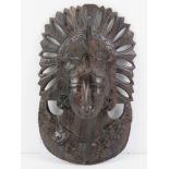 A carved and pierced oriental hardwood 'mask' of a female in ceremonial headdress, possibly Tibetan,