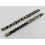 Two carved wooden recorder / whistle type musical instruments decorated with pressed metal 'leaves'