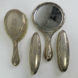 A HM silver dressing table set comprising hand mirror, hairbrush and pair of brushes.