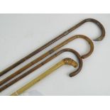 Four bamboo walking canes; one having sterling silver collar,