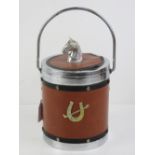 A c1970s ice bucket having leatherette cover with horses head handle and horseshoe design to front.