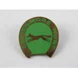 A Cottesmore Hunt badge in brass and green enamel.