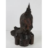 A Balinese carved wooden figurine of a goddess, 21cm high.