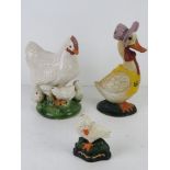 A Mother Goose cast iron contemporary door stops together with a small duck and a ceramic chicken