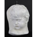 A white painted plaster wall plaque of a cherubic child, 25cm high.