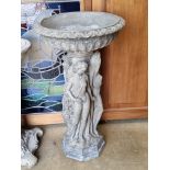 A pre-cast birdbath raised over classical style females, 83cm high.