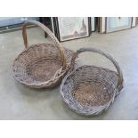 A pair of graduated wicker flower baskets with loop handles, largest 69 x 59 x 59cm.