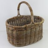 A Wicker fireside log basket having loop handle over 51cm wide.