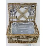 An as new wicker picnic hamper for two including thermal lining, cutlery, plates, bottle opener,