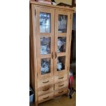 A contemporary oak twin glazed door cabinet having drawers under, 80 x 44.5 x 183cm.