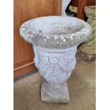 A pre-cast stone planter decorated with swags, 58cm high.