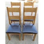 A set of four contemporary oak chairs having leatherette seats.