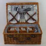 A Wicker picnic hamper opening to reveal cutlery within.