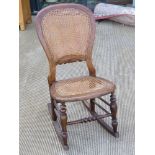 A cane seated rocking chair.
