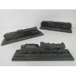 Three decorative carved coal model trains.