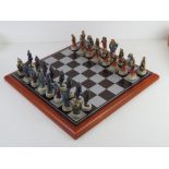 A hand painted good versus evil chess set in original packaging.